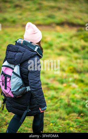 Photo verticale d'une personne en randonnée dans la campagne près de Neumarkt in der Oberpfalz, en Bavière, Allemagne. Le randonneur, vêtu d'un manteau matelassé sombre, rose Banque D'Images