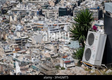 09 septembre 2026, Grèce, Athènes : Une unité extérieure d’un climatiseur Fujitsu est posée sur une corniche rocheuse surélevée, avec le paysage urbain densément construit d’Athènes s’étendant derrière elle. Photo : Marijan Murat/dpa Banque D'Images