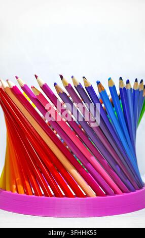 Crayons de couleur taillés disposés en éventail sur un fond blanc avec beaucoup d'espace libre, représentant la créativité, le dessin, l'éducation et l'art. Banque D'Images