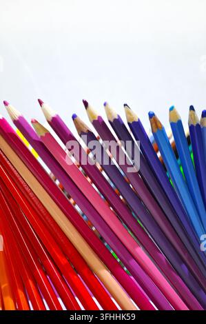 Crayons de couleur taillés disposés en éventail sur un fond blanc avec beaucoup d'espace libre, représentant la créativité, le dessin, l'éducation et l'art. Banque D'Images
