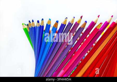 Crayons de couleur taillés disposés en éventail sur un fond blanc avec beaucoup d'espace libre, représentant la créativité, le dessin, l'éducation et l'art. Banque D'Images