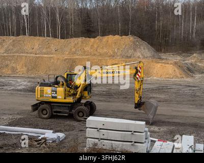 Wroclaw, Pologne – 8 mars 2026 : Excavateur sur roues Komatsu garé sur un chantier en terre, mettant en évidence l'équipement de machines lourdes utilisé dans les grands projets Banque D'Images