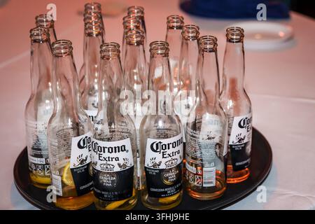 RIGA, LETTONIE. 30 août 2026. Bouteilles vides de bière Corona Extra avec des tranches de citron laissées sur un plateau sur une table de banquet après un événement ou une fête Banque D'Images