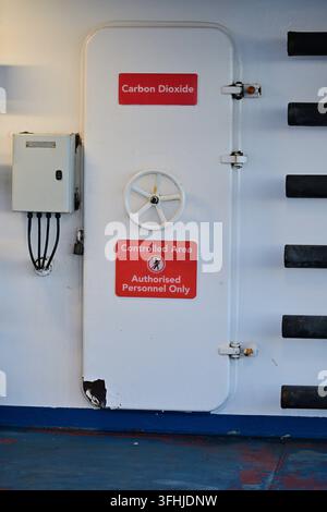 Dunkerque, France - 4 avril 2026 : Porte métallique blanche avec panneaux de dioxyde de carbone et câbles électriques visibles à proximité Banque D'Images