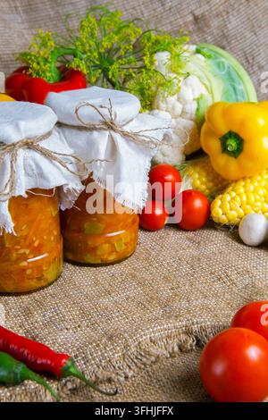 des pots avec des fournitures d'hiver, des banques avec de la salade sont sur la table avec des légumes Banque D'Images