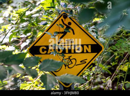 Un panneau d'avertissement jaune en forme de losange apparaît pour avertir les cyclistes d'un danger où une roue de vélo peut se coincer, comme des voies parallèles, des grilles ou Banque D'Images