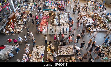Vue aérienne d'un marché aux puces animé à Barcelone, en Espagne, avec des acheteurs parcourant des étals bondés d'antiquités, de produits vintage et de pièces de collection, créant une atmosphère vivante Banque D'Images