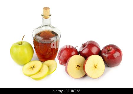 Une bouteille en verre de cidre de pomme est posée à côté de pommes rouges et vertes fraîches sur un fond blanc isolé. Banque D'Images