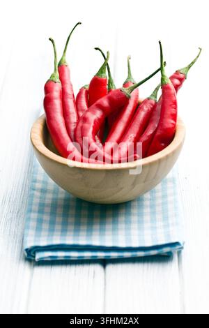 Chili Peppers dans bol en bois sur une serviette à carreaux Banque D'Images