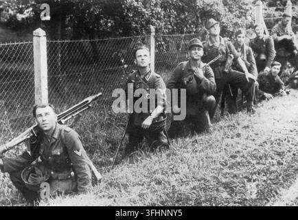 Soldats allemands sur le front de l'Est, cachés dans un fossé au bord de la route, observant un avion soviétique, l'un d'eux portant une mitrailleuse MG-42, septembre 1944. Banque D'Images