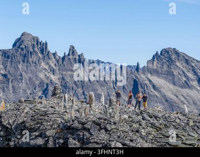 Vue aérienne du sommet Kongen avec des randonneurs sur une crête rocheuse entourée de cairns sous un ciel bleu clair dans la municipalité de Rauma, Mor Banque D'Images