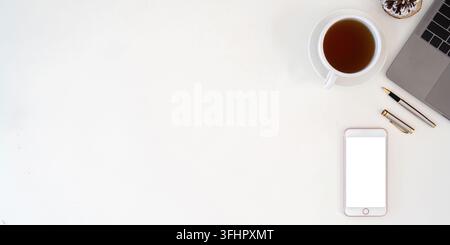 Smartphone vue de dessus avec écran vide, ordinateur portable et tasse à café sur le bureau. Copiez l'espace pour votre texte Banque D'Images