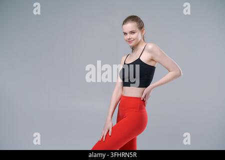 Une femme porte un débardeur noir et un pantalon rouge Banque D'Images