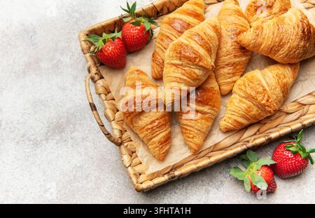 Des croissants fraîchement cuits et des fraises créant une scène de petit-déjeuner délicieuse Banque D'Images