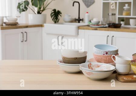 Ménages et épuisement domestique, pile de vaisselle sale sur une table de cuisine après un repas avec des bols et des tasses en désordre dans un intérieur de maison Banque D'Images