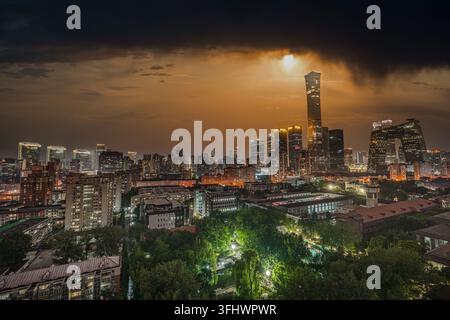Ciel urbain du quartier des affaires de Pékin avec des nuages sombres et la lueur du coucher de soleil entrelacés Banque D'Images