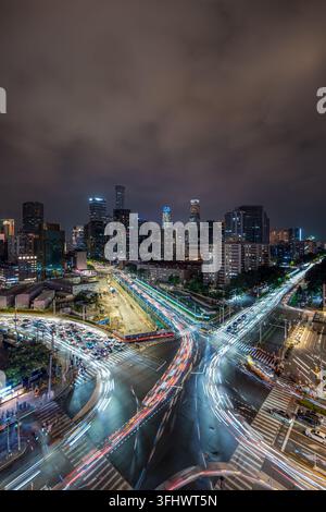 Traînées de lumière du trafic serpentant à travers le pont de Guomao Banque D'Images