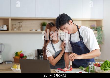 Couple heureux cuisinant ensemble dans la cuisine moderne Banque D'Images