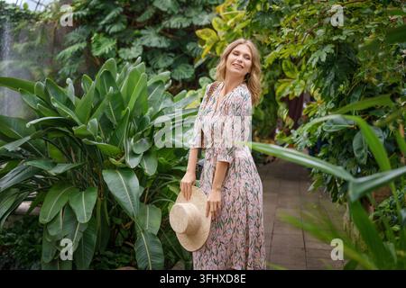 Belle femme heureuse portant un chapeau de paille dans le parc Banque D'Images