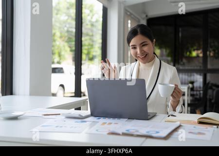 Femme asiatique tenant un webinar ou offrant une consultation d'affaires en ligne à un client. Entrepreneure ou gestionnaire d'entreprise ayant une te en ligne à distance Banque D'Images