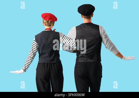 Couple de pantomimistes sur fond bleu, vue arrière Banque D'Images