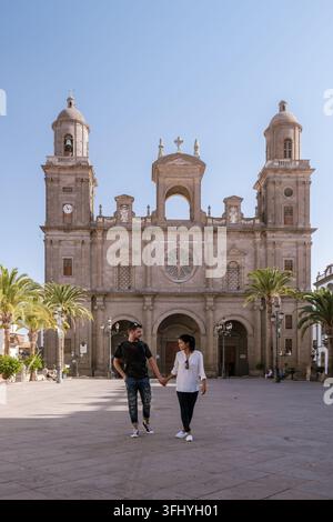 Un couple profite d'une promenade romantique à travers la Plaza de Santa Ana, entourée d'une architecture étonnante et de palmiers à Gran Canaria, en Espagne. Le vibrant atm Banque D'Images