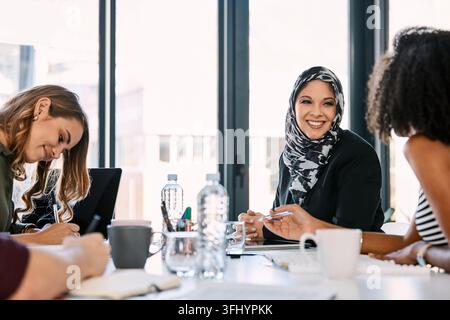 Créatif, femmes et riant avec des idées au bureau, discussions et brainstorming avec des papiers en réunion. Marketing, collaboration et personnes avec Banque D'Images