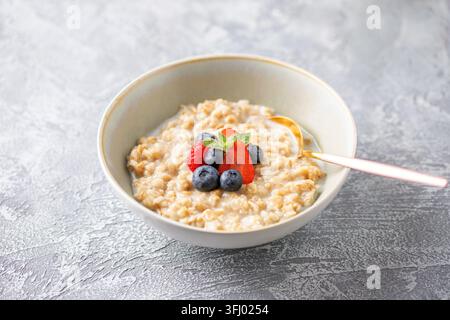Savoureux porridge d'avoine avec fraises, framboises, bleuets dans un bol. Petit déjeuner sain Banque D'Images