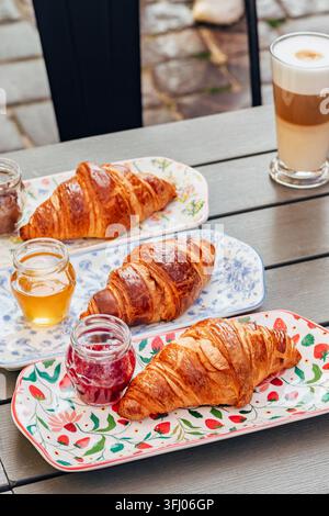 Croissants servis avec de la confiture, du miel et un latte Banque D'Images