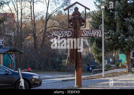 Szklarska Poręba, Pologne – 18 décembre 2025 : Un panneau en bois rustique orné d’une figure décorative indique le chemin vers une cascade, marquant un sentier naturel Banque D'Images