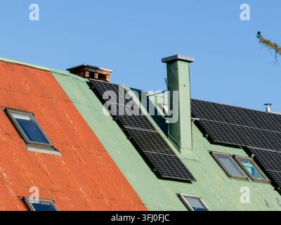 Modules photovoltaïques modernes montés sur un toit en tôle ondulée, présentant une solution énergétique écologique pour les maisons et un engagement envers le vert Banque D'Images