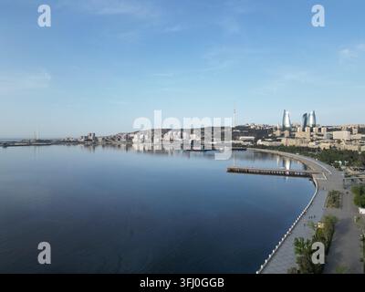 Vue aérienne du front de mer et de la skyline de la ville de Bakou, Azerbaïdjan, mettant en vedue les Tours de Flamme et la mer Caspienne Banque D'Images