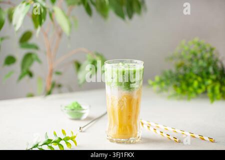 Latte matcha à la mangue glacée en verre sur la table Banque D'Images