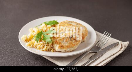 Escalopes de poulet ou de légumes avec un plat d'accompagnement de boulgour dans une assiette sur la table. Nutrition diététique Banque D'Images