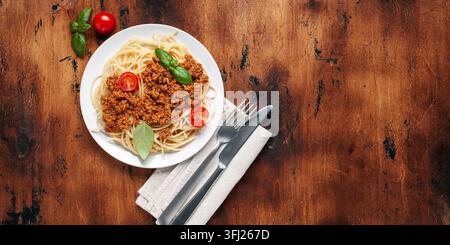 Pâtes Spaghetti Bolognese dans une assiette blanche sur fond en bois. La sauce Bolognese est un plat classique de la cuisine italienne. Populaire italienne Banque D'Images