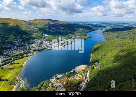 Vue aérienne de Llyn Padarn et du village de Llanberis dans le parc national de Snowdonia, au nord du Pays de Galles, avec des coteaux boisés s'élevant depuis les eaux profondes Banque D'Images