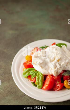Burrata au fromage italien avec tomates sur une assiette. Copier l'espace Banque D'Images