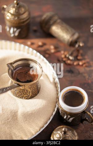 Café turc traditionnel au cezve préparé sur du sable chaud. Banque D'Images