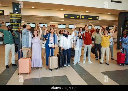 Groupe divers de personnes célébrant le succès et triomphant à l'aéroport Banque D'Images