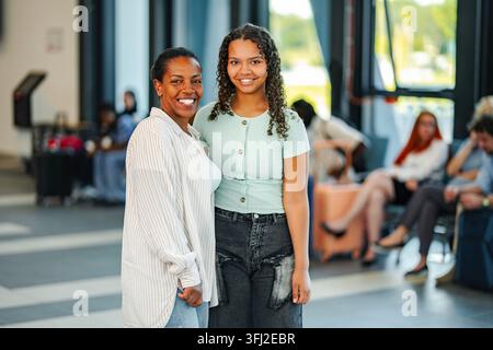 Mère et fille souriant ensemble pendant un voyage à l'aéroport Banque D'Images