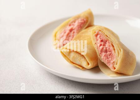 Crêpes farcies ou crêpes dans une assiette et confiture sur la table. Petit déjeuner savoureux Banque D'Images