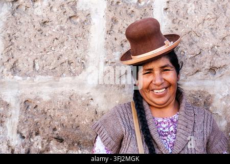 Femme quechua péruvienne souriant portant un chapeau local vêtu d'une tenue traditionnelle péruvienne, Arequipa, Pérou. Banque D'Images