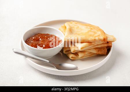 Crêpes ou crêpes dans une assiette et confiture sur la table. Petit déjeuner savoureux Banque D'Images