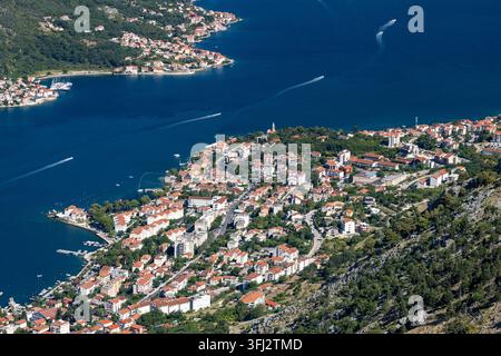 5 juillet 2026, Kotor, Monténégro, Une vue aérienne montre des maisons d'habitation aux toits de tuiles rouges alignées le long d'une côte en pente, des rues étroites et sinueuses, vertes Banque D'Images