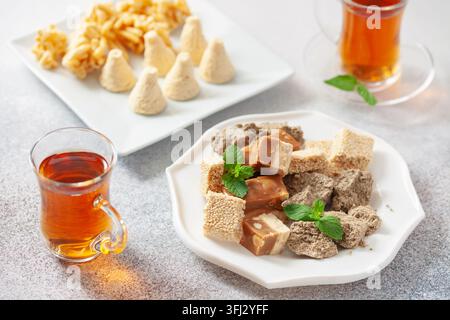 Douceur orientale. Délice turc. Nougat, halva et thé sur une table. Banque D'Images