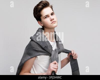 Jeune et beau hipster adolescent posant devant un fond blanc isolé Banque D'Images