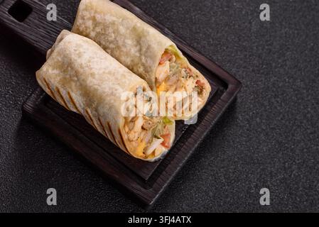 Shawarma ou döner au poulet grillé avec tomates, concombre et sauces, nourriture à emporter. Shawarma comme fond pour votre design. Banque D'Images