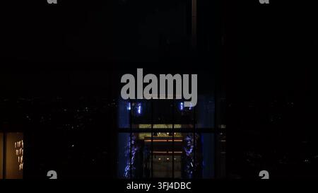 Plan aérien ascendant du Comcast Center à Philadelphie. La salle de sport et les installations du Four Seasons Hotel à travers les vitres la nuit, Pennsylvanie. Banque D'Images