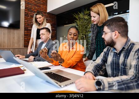 Équipe d'affaires diversifiée collaborant lors d'une réunion dans un bureau moderne Banque D'Images