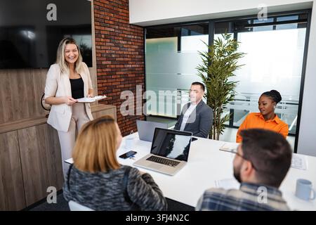 Femme d'affaires dirigeant une réunion avec une équipe diversifiée dans un bureau moderne Banque D'Images